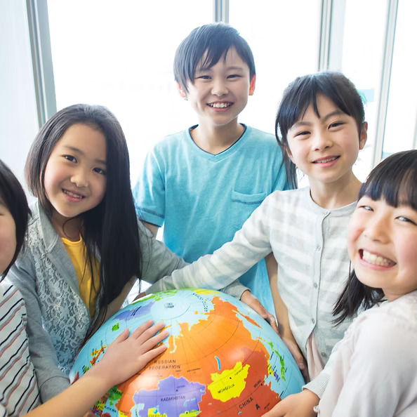 Children standing around globe